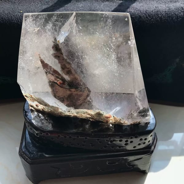 Side view with a natural crusty rough edge along the bottom of the crystal