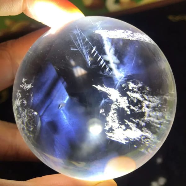 Dense blue needle sheets crossing the sphere beside white snow-like flakes