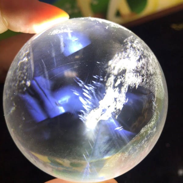 Close view of white snowflake inclusions with fine blue needles behind
