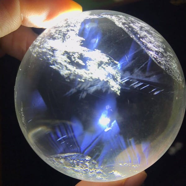 White flake clusters scattered over deep blue needle zones in the sphere