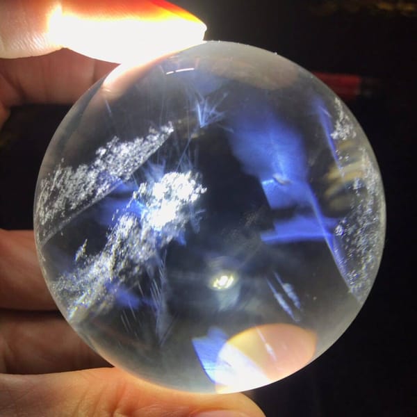 Hand-held sphere with blue needle sheets crossing diagonally through it