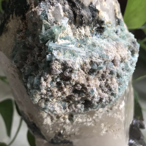 Detail of blue tourmaline crystals lying across the granular matrix