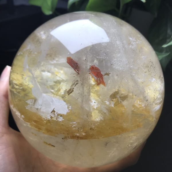 Front view of red flakes and white inclusion beneath a bright window reflection