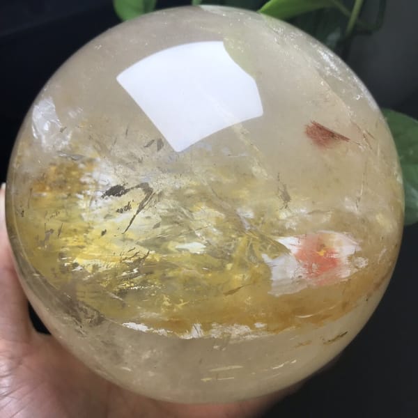 Yellow inclusion band and pink-red patch on the right side of the sphere