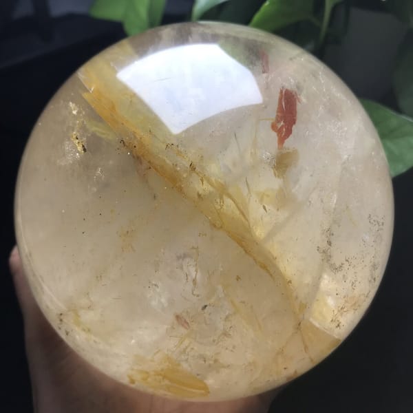 Diagonal golden plane crossing the sphere with a red flake at top right