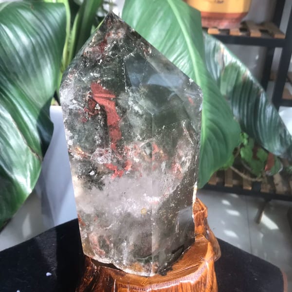 Rust-red flake and green phantoms inside the polished point