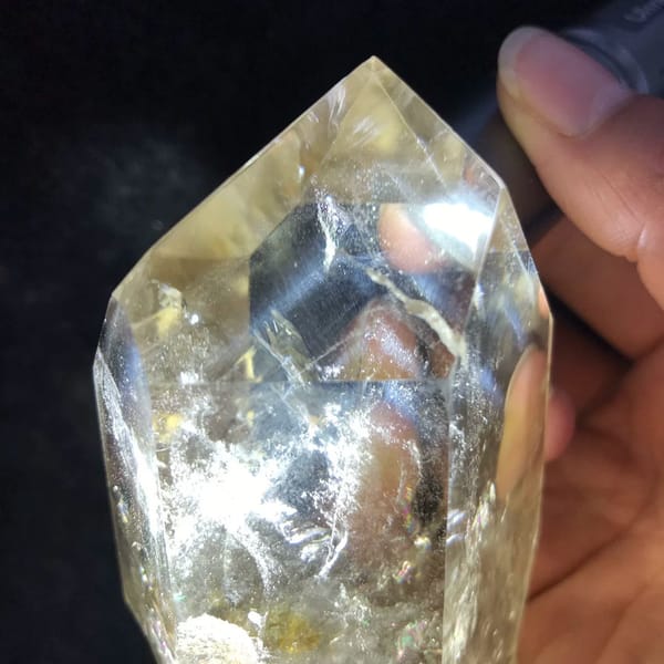 Torch-lit termination revealing an inner skeletal crystal on dark cloth