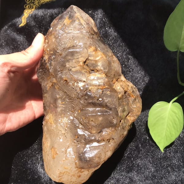 Narrow side of the crystal held in hand, etched glassy surface