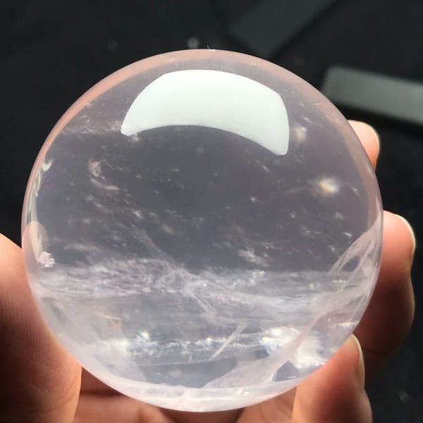 Icy pale pink rose quartz sphere with a white snowflake band below centre