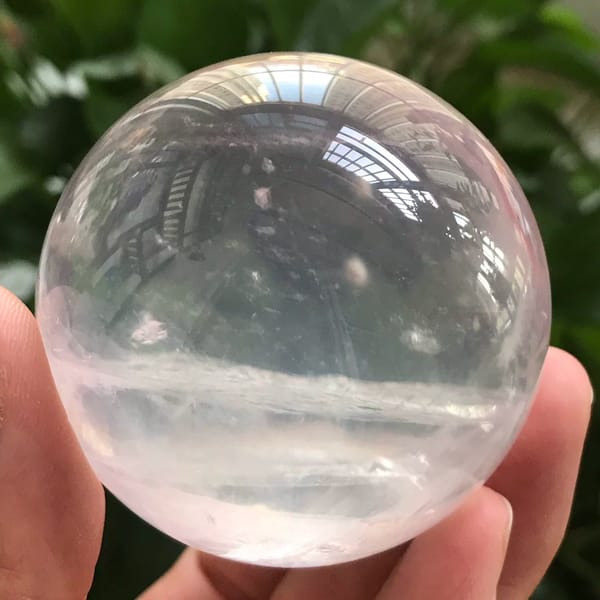 Sphere outdoors with a garden reflection and a wispy white band