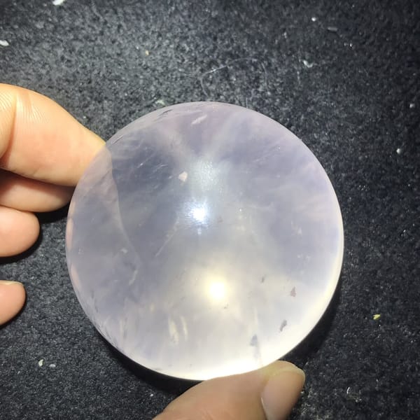 Six-ray star pattern visible on the pale pink sphere under a light