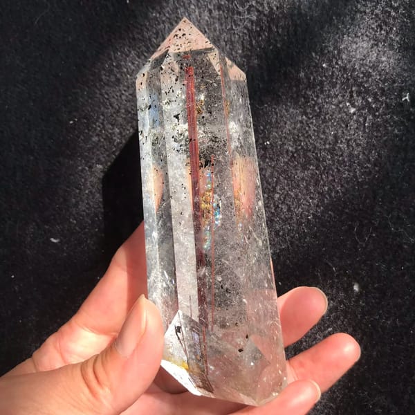 Side face showing red rutile and speckled green phantom near the tip