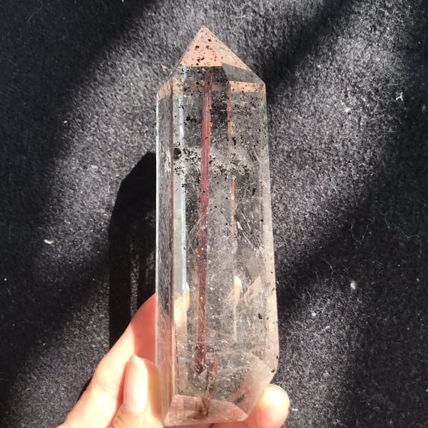Clear point with the rutile rod and phantom specks along one side