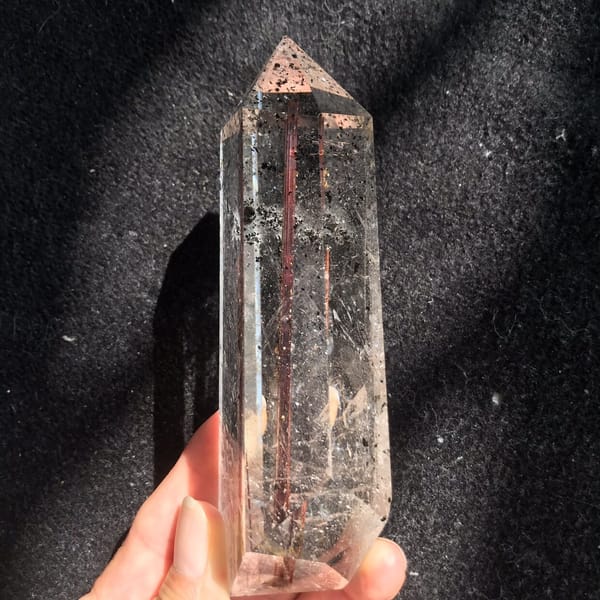 Straight red rutile running down the centre of the polished point