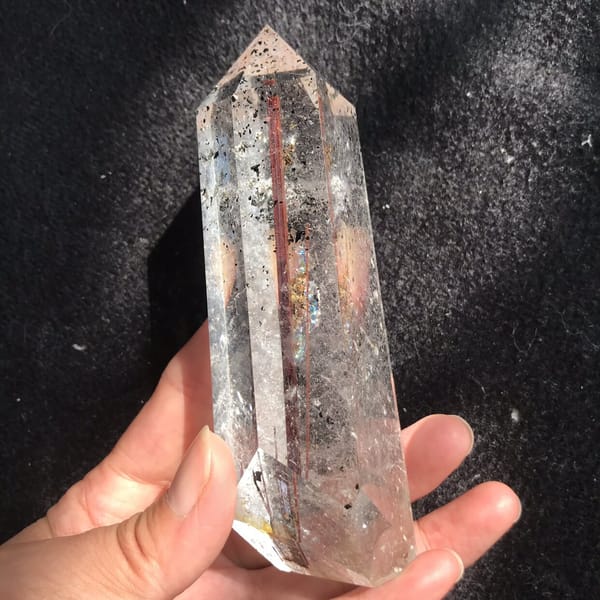 Point in hand showing rutile and golden specks near the base