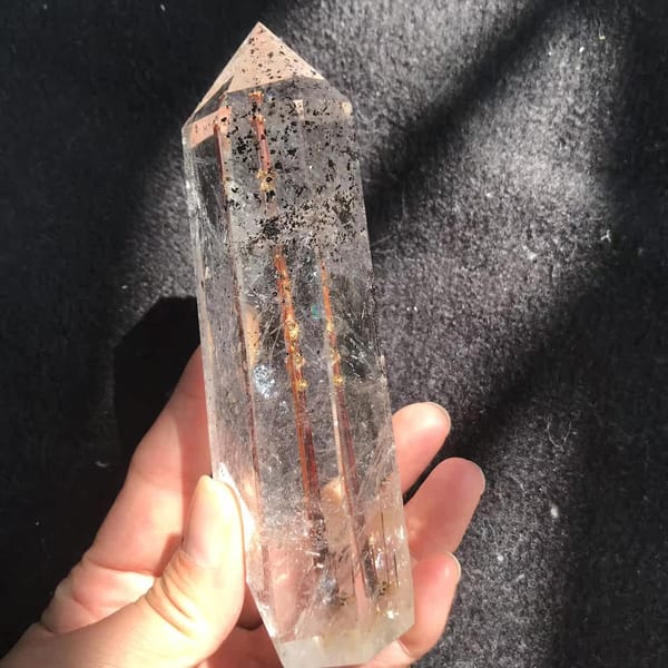 Copper rutile glinting gold and red beside speckled phantom