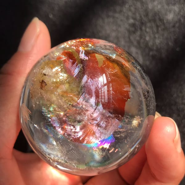 View from below into the base showing red clouds and rainbows
