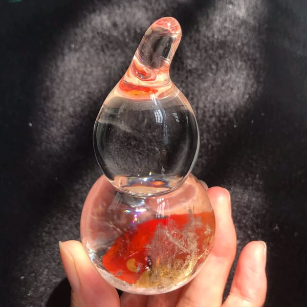 Red fire inclusions swirling in the lower bulb under sunlight