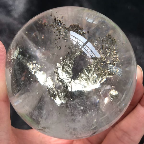 Metallic tree inclusion seen from below with flakes scattered around