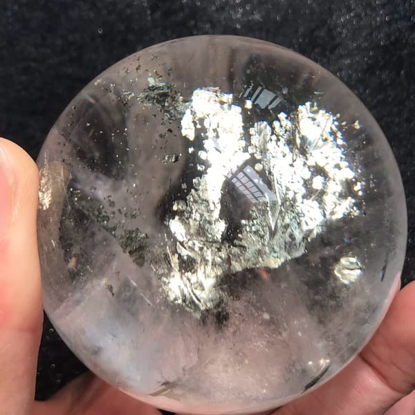 Silvery-gold chalcopyrite branches spreading through the clear sphere