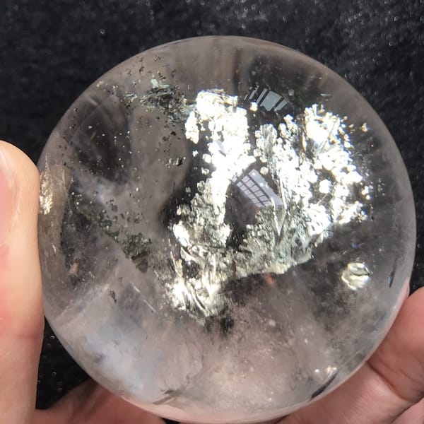 Chalcopyrite tree with dark specks scattered around it in clear quartz