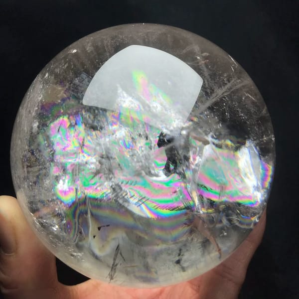 Clear quartz sphere with rainbow layers reaching to the right edge