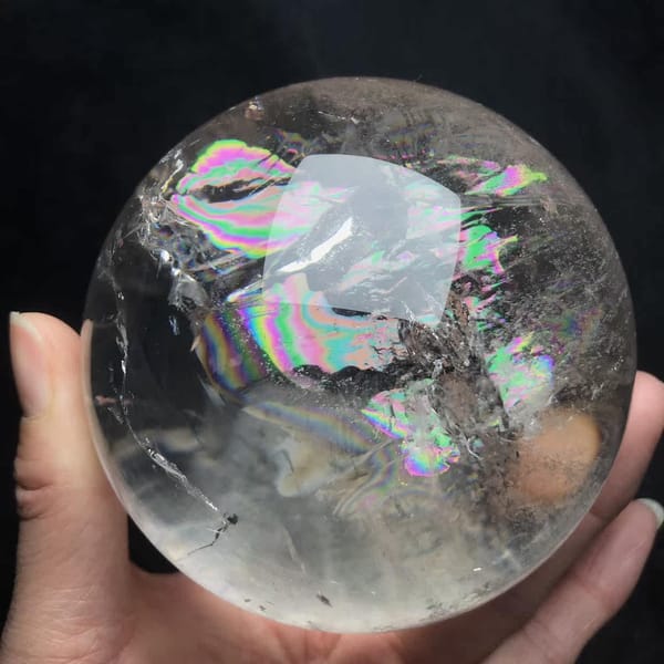 Sphere turned to show rainbow bands and a peach-coloured spot
