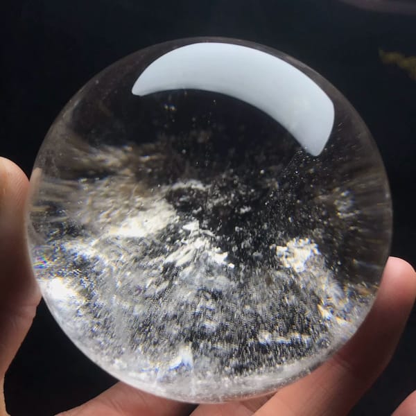 Swirling cloud of fine white flecks inside the polished sphere