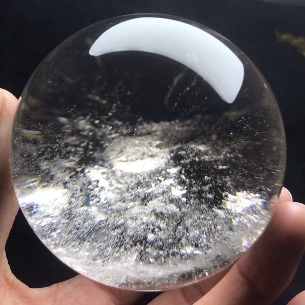 Dense white cloud beneath the bright reflection on the sphere