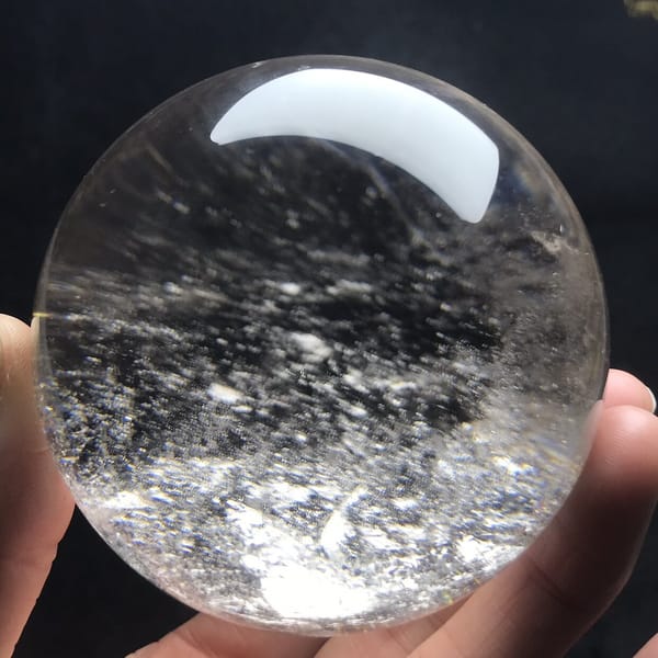 Dark haze and scattered white specks across the clear sphere