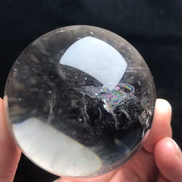 Small rainbow feather inside the sphere beside a bright reflection