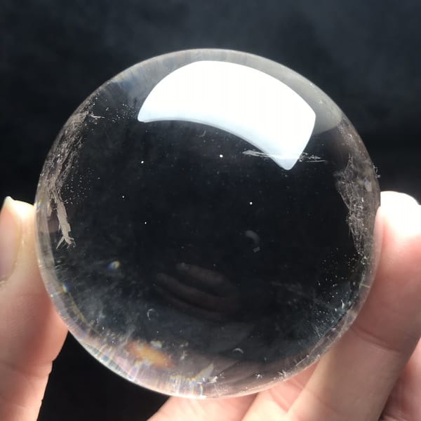 Polished sphere showing deep clarity and a faint veil on the side