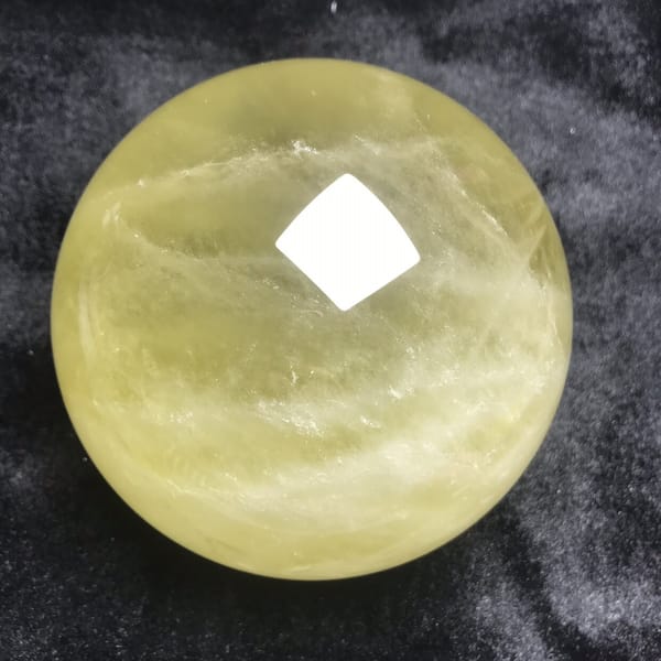 Pale band and wispy veils across the yellow citrine sphere
