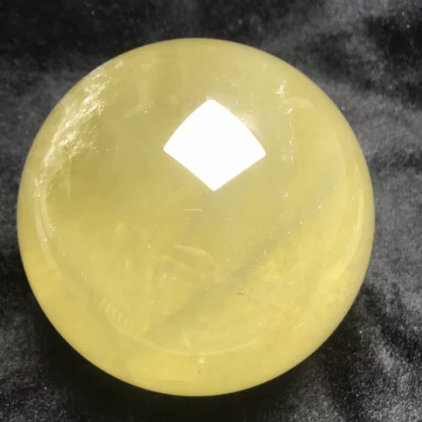 Warm yellow glow of the large citrine against black cloth