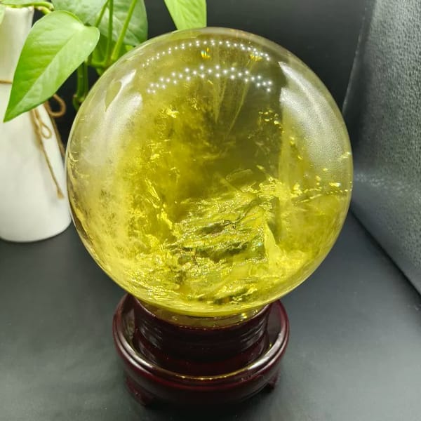 Citrine sphere showing layered yellow inclusions in the lower half
