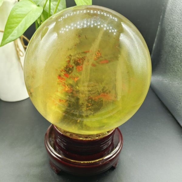 Patch of orange-red speckles inside the large citrine sphere