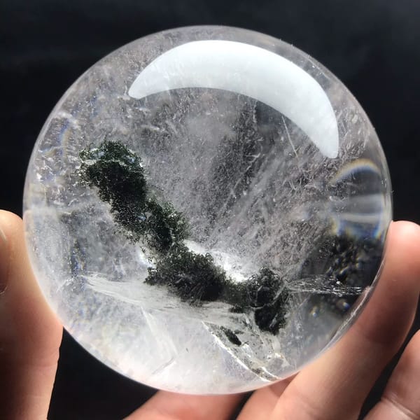 Green phantom bending across the sphere above a pale mica blade