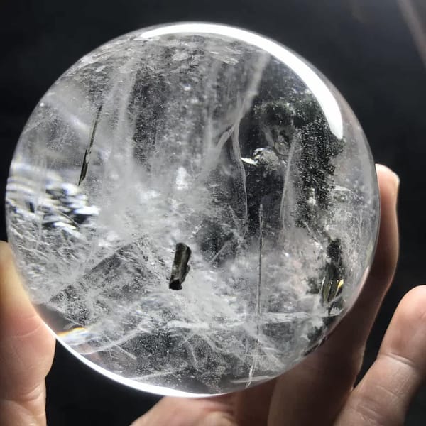 Small dark crystal among white veils on another side of the sphere
