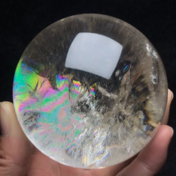 Broad rainbow sweep across the lower left of the sphere