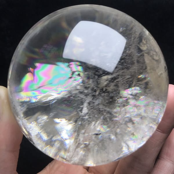 Rainbow and grey-white fan of veils at the centre of the sphere