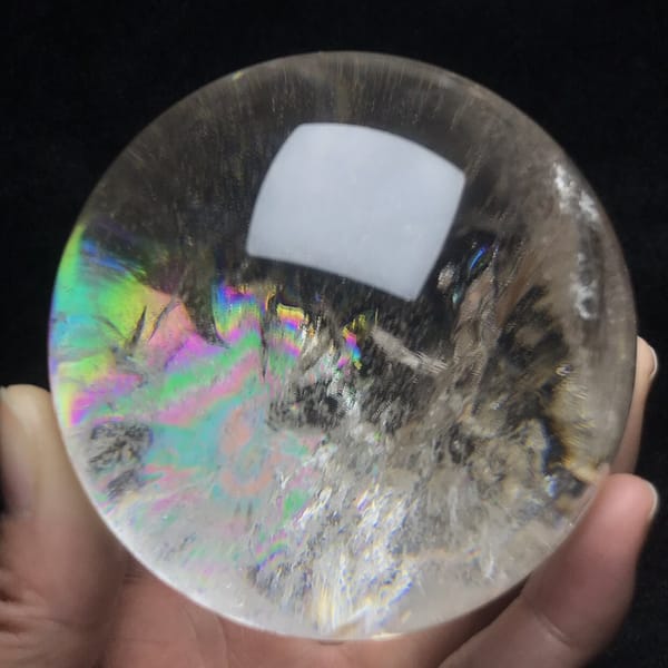 Pastel rainbow glow spreading over the left half of the sphere