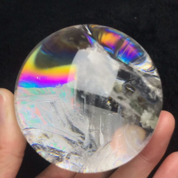 Bright rainbow stripe at the upper left of the clear sphere