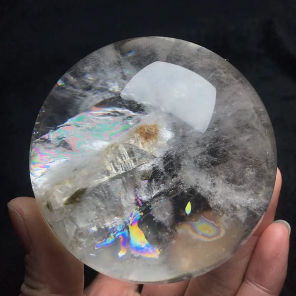 Butterfly-shaped rainbow below the enclosed crystal in the sphere