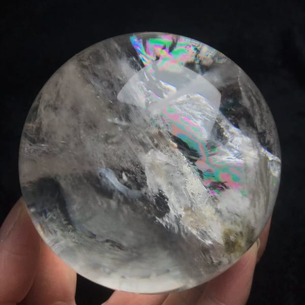 Angled view of the enclosed crystal with rainbow flashes above