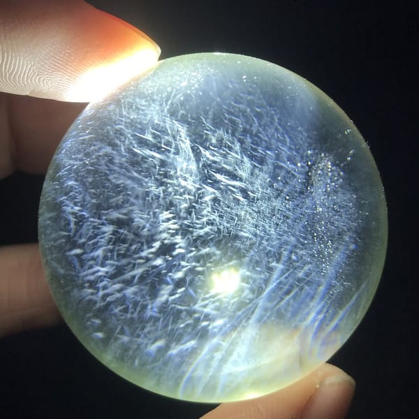 Fine blue needles crisscrossing the pale yellow citrine ball