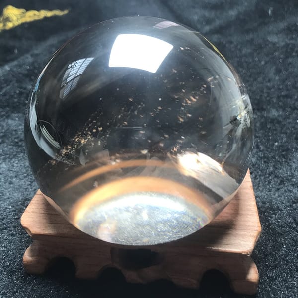 Half sphere on its wooden stand with sparkling flecks inside