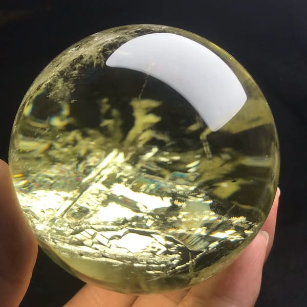 Golden citrine sphere with shimmering white veil planes in the lower half