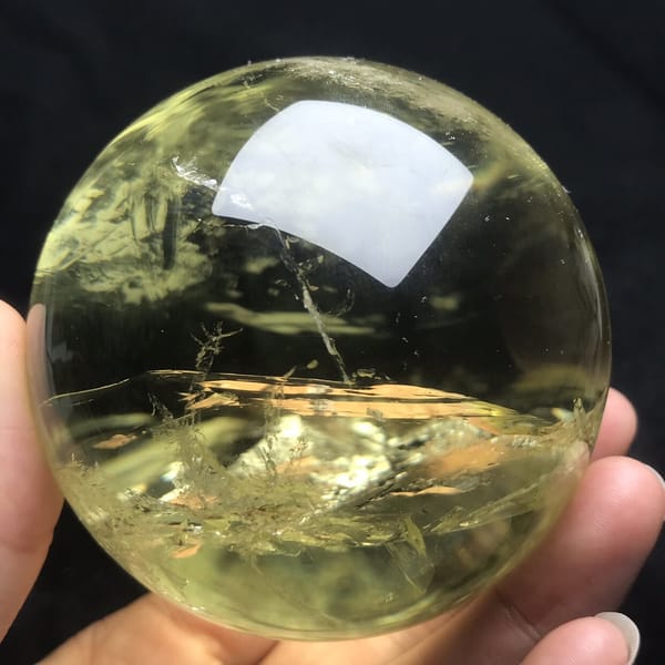 Clear yellow sphere with a silvery veil band near the bottom