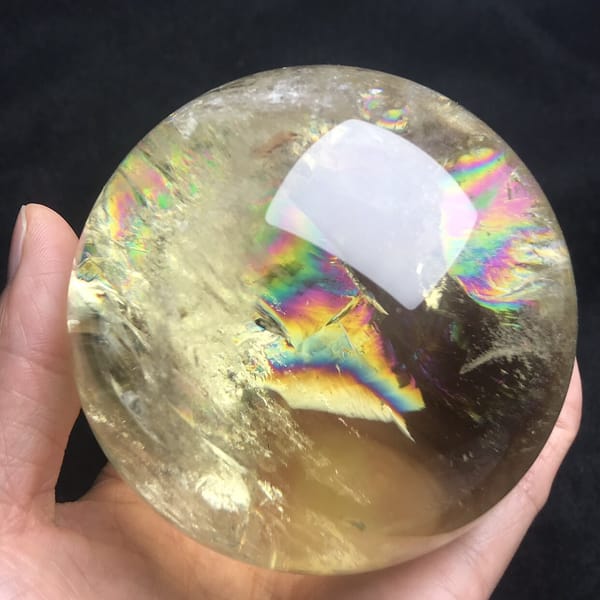 Rainbow layers spreading through the champagne-gold quartz of the sphere