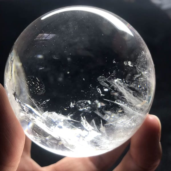 White veils fanning up from the lower edge of the sphere